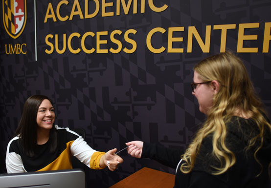 An informal portrait of two students in an office environment.