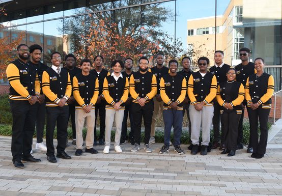 A group of young african-americans standing in front of a building on campus