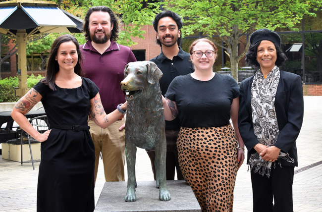 group photo of the AETP staff standing around the staue of true grit