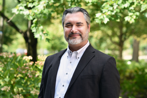 A senior staff member standing outside on academic row